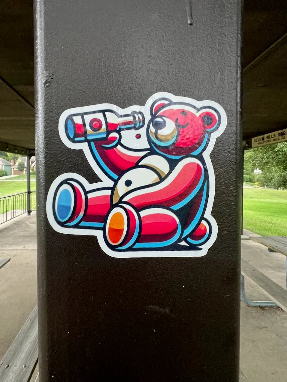 drinking bear sticker on a brown pole