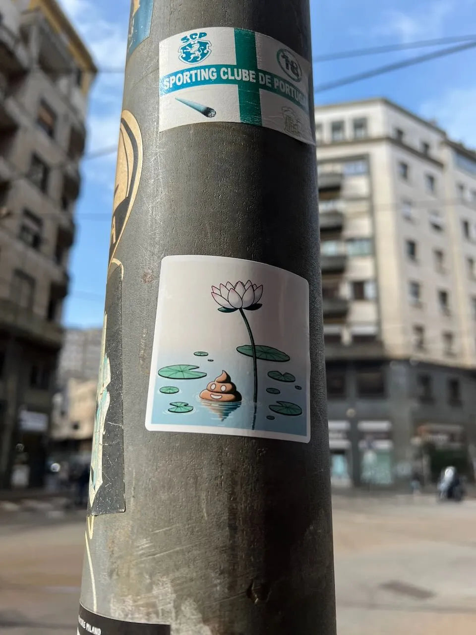 Square sticker below depicting a lotus flower, lily pads, and a spiral shell of poo in blue water.